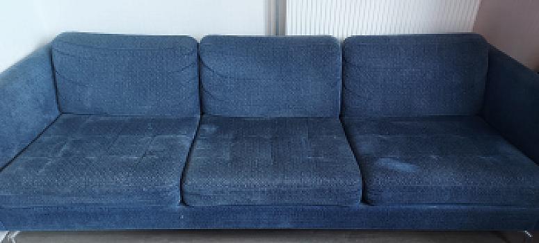 Driezitsbank van blauwe stof en poef/hocker